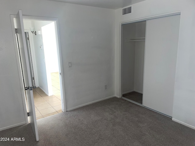 unfurnished bedroom featuring dark colored carpet and a closet