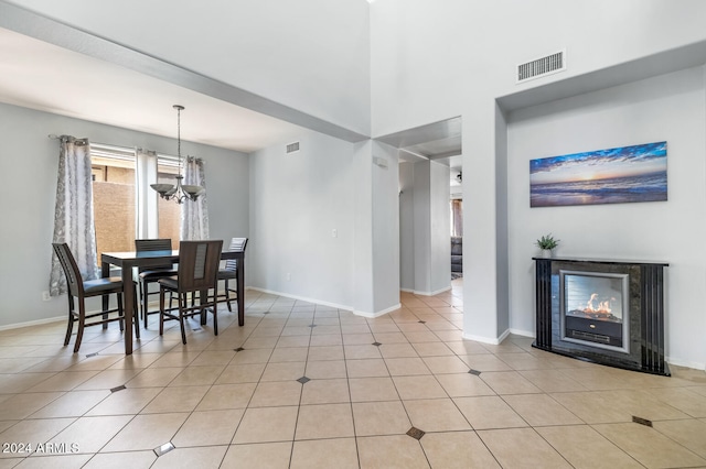 dining room featuring light tile patterned floors, a multi sided fireplace, and a chandelier