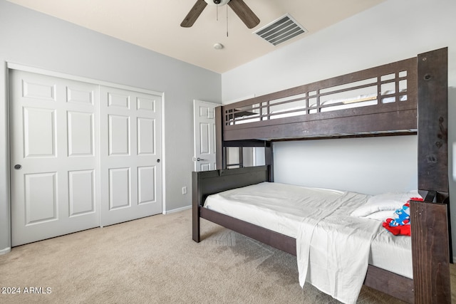 carpeted bedroom featuring ceiling fan and a closet