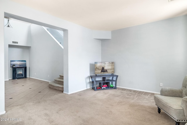 sitting room with light carpet and a fireplace