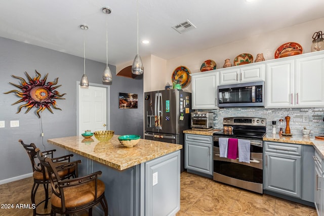 19104 N Smith Dr, Maricopa, AZ 85139 - kitchen with visible vents, a kitchen island, stainless steel appliances, gray cabinetry, and backsplash
