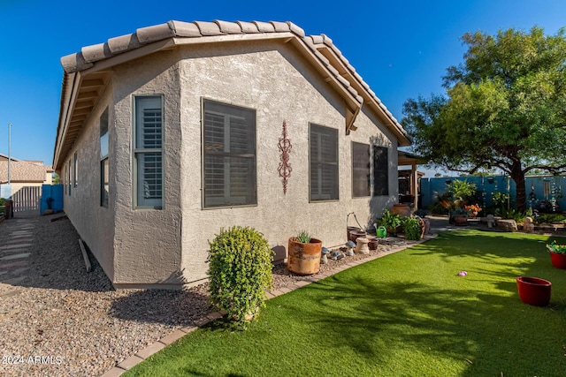 19104 N Smith Dr, Maricopa, AZ 85139 - view of property exterior featuring a fenced backyard, stucco siding, and a lawn
