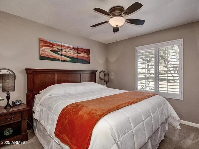 carpeted bedroom featuring baseboards and a ceiling fan