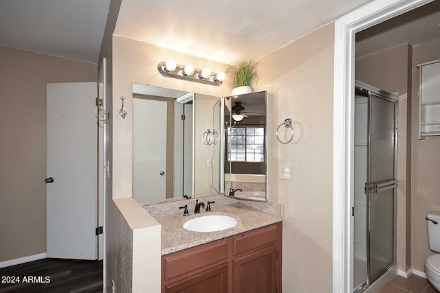 bathroom featuring walk in shower, vanity, ceiling fan, and toilet