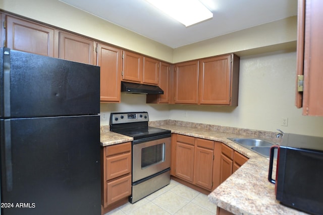 kitchen featuring light tile patterned floors, black fridge, stainless steel range with electric stovetop, and sink