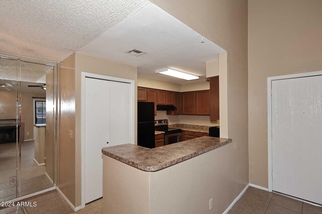 unfurnished living room featuring lofted ceiling, a tile fireplace, ceiling fan, light tile patterned floors, and a textured ceiling