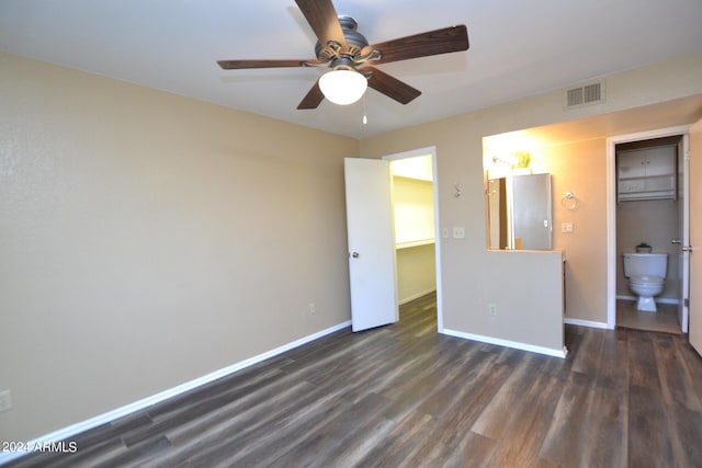 unfurnished bedroom featuring ceiling fan, a spacious closet, connected bathroom, dark hardwood / wood-style flooring, and a closet