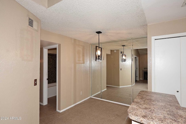 unfurnished dining area with tile patterned floors and a textured ceiling