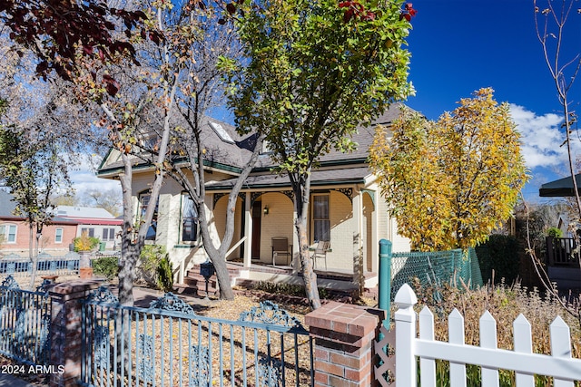 view of property hidden behind natural elements with covered porch