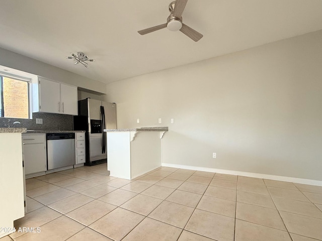 kitchen featuring backsplash, kitchen peninsula, white cabinets, and appliances with stainless steel finishes