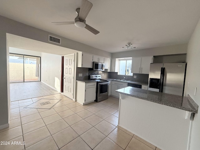 kitchen with decorative backsplash, plenty of natural light, ceiling fan, and appliances with stainless steel finishes