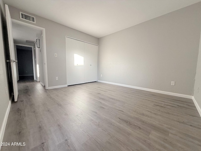 unfurnished bedroom featuring hardwood / wood-style flooring and a closet