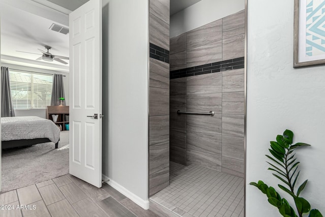 bathroom featuring a tile shower and ceiling fan