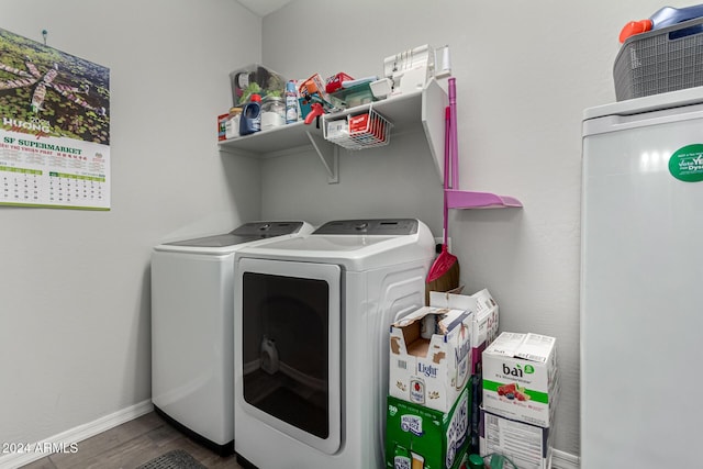 washroom with dark hardwood / wood-style floors and washing machine and dryer