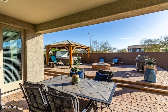 view of patio / terrace with a fire pit, a jacuzzi, a gazebo, and a grill