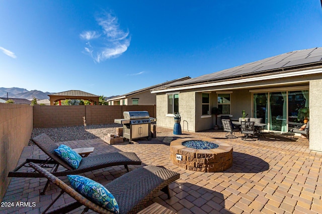 view of patio / terrace featuring a mountain view, an outdoor fire pit, and a grill