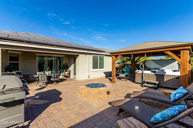 view of patio featuring an outdoor fire pit, a gazebo, area for grilling, and a hot tub