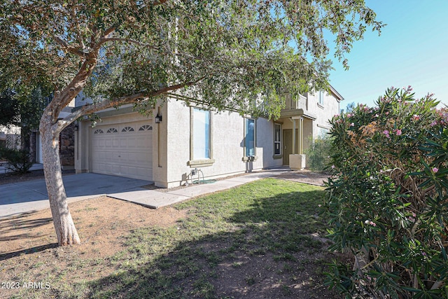 view of front of house featuring driveway, a garage, and stucco siding