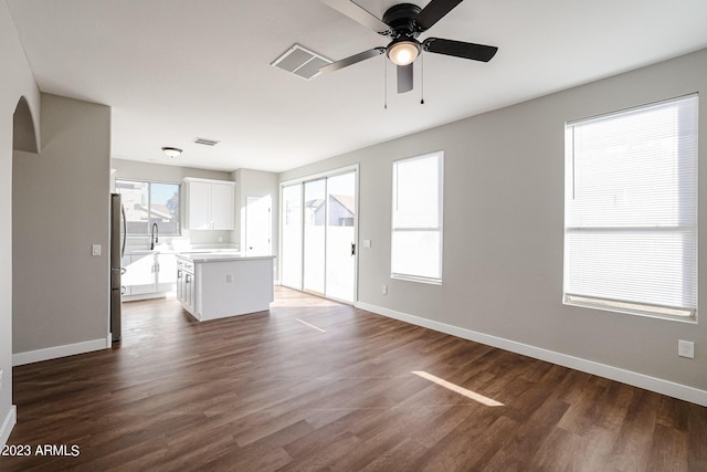 unfurnished living room with ceiling fan, dark hardwood / wood-style flooring, and sink