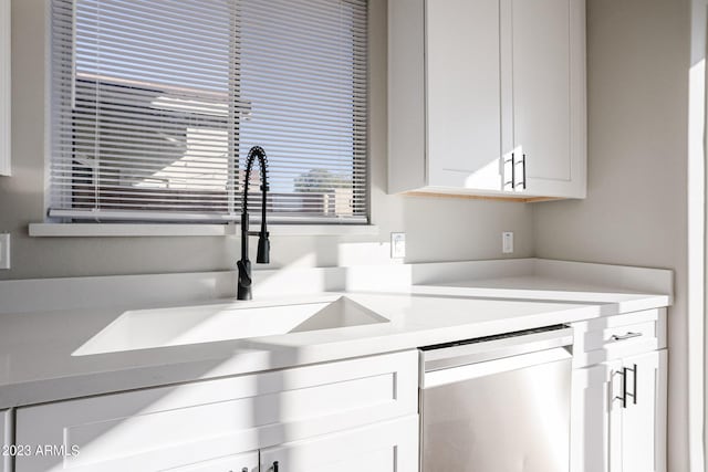 kitchen with dishwasher, light countertops, a sink, and white cabinets