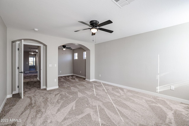 unfurnished bedroom with light carpet, multiple windows, and ceiling fan