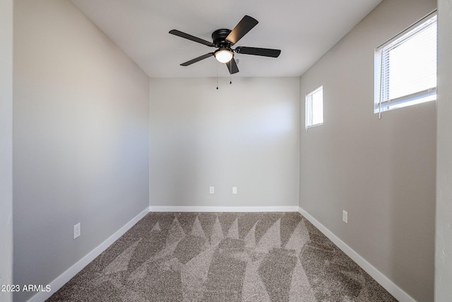 carpeted empty room featuring ceiling fan and baseboards