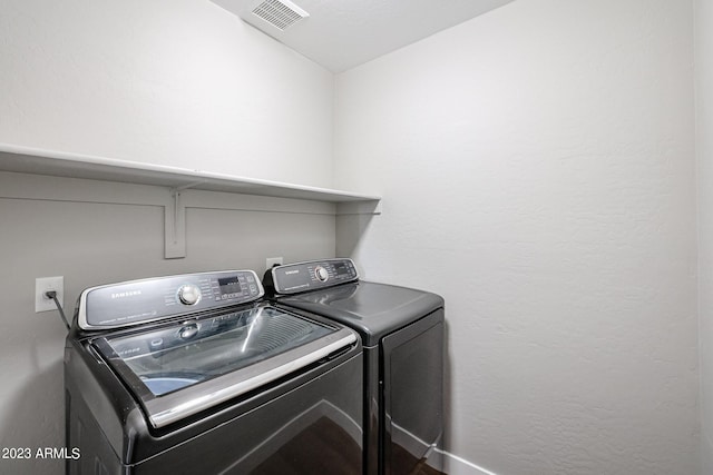 washroom featuring laundry area, visible vents, and separate washer and dryer