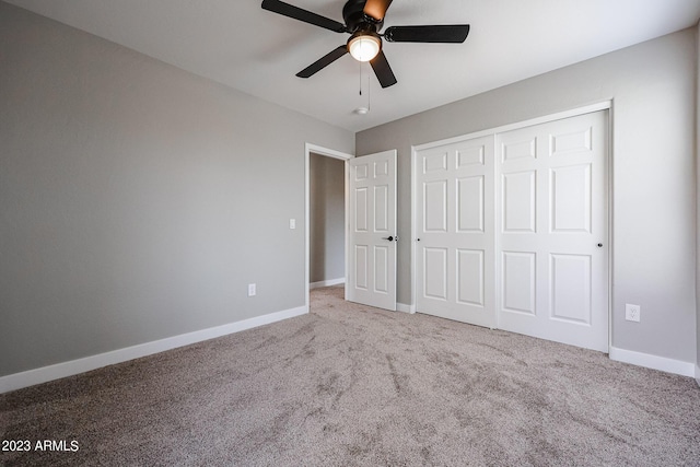 unfurnished bedroom with a closet, carpet, a ceiling fan, and baseboards