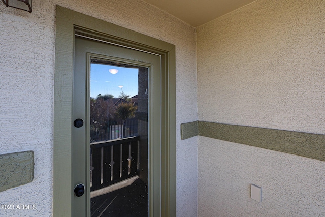 doorway to property featuring stucco siding