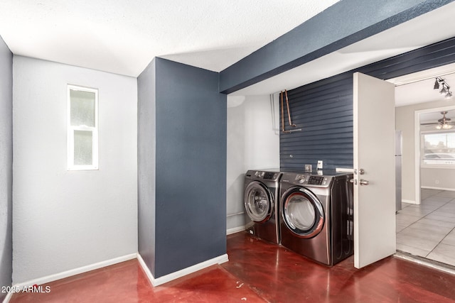 washroom with baseboards, laundry area, a textured ceiling, and washer and dryer