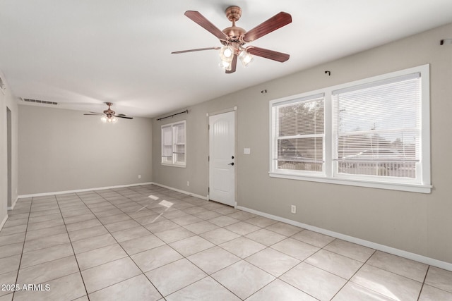 empty room with ceiling fan, visible vents, and baseboards