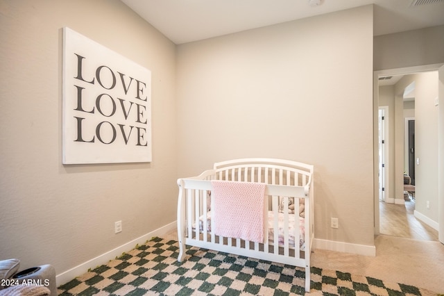 bedroom with carpet floors and a nursery area