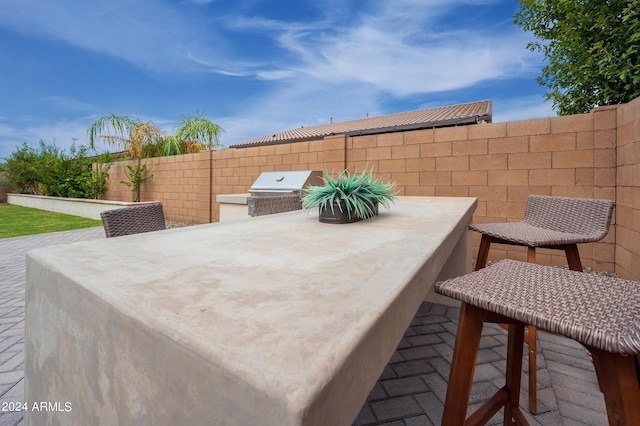 view of patio with area for grilling and a grill