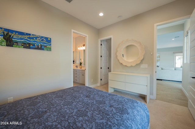 bedroom featuring light wood-type flooring and ensuite bath