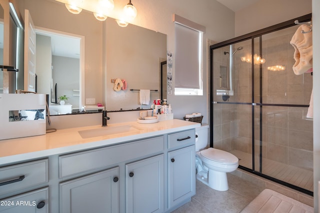 bathroom with tile patterned flooring, vanity, toilet, and walk in shower