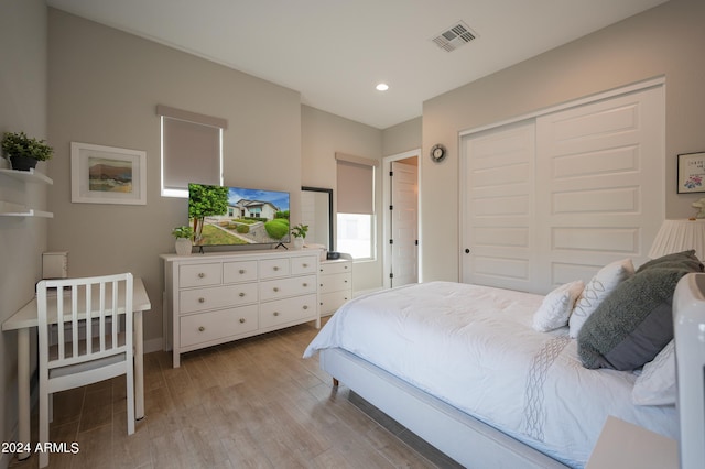 bedroom with light hardwood / wood-style floors and a closet