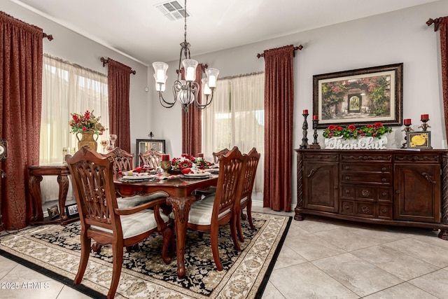 dining area with visible vents, a notable chandelier, and light tile patterned flooring