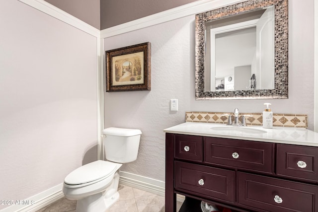 bathroom with tile patterned floors, vanity, toilet, and baseboards