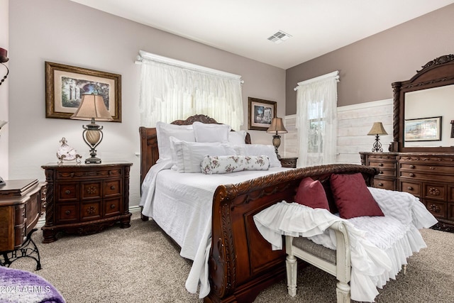 bedroom featuring visible vents, carpet flooring, and multiple windows