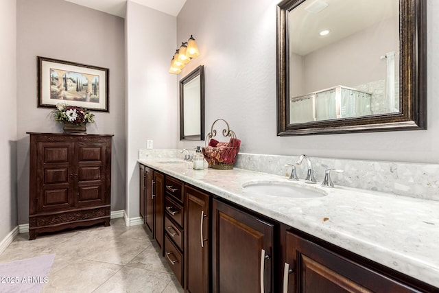 bathroom featuring double vanity, tile patterned flooring, walk in shower, and a sink