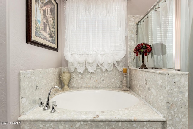 bathroom featuring a garden tub and a wealth of natural light