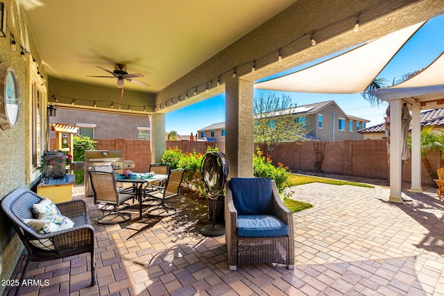 view of patio with ceiling fan, outdoor dining area, area for grilling, and a fenced backyard