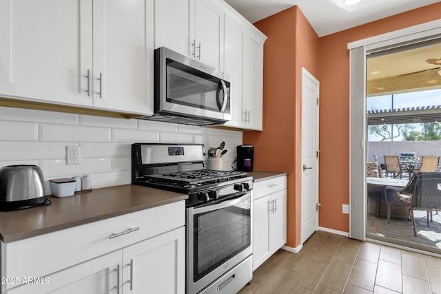 kitchen featuring decorative backsplash, stainless steel appliances, and white cabinets