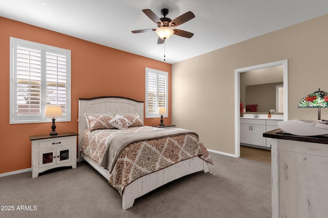 carpeted bedroom with ensuite bathroom and ceiling fan