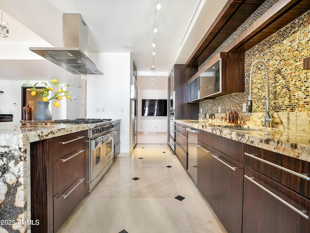 114 W Adams St Ph, Ph, Phoenix, AZ 85003 - kitchen with range hood, decorative backsplash, track lighting, light stone countertops, and stainless steel appliances