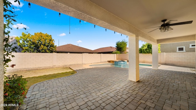 view of patio / terrace with ceiling fan and an in ground hot tub