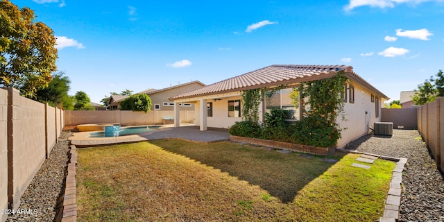 back of property featuring a fenced in pool, central AC, a lawn, and a patio