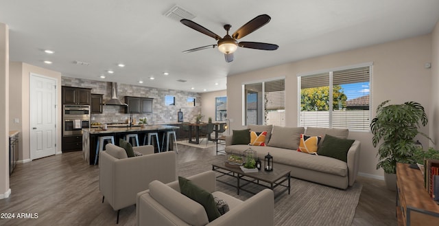 living room with ceiling fan and dark wood-type flooring