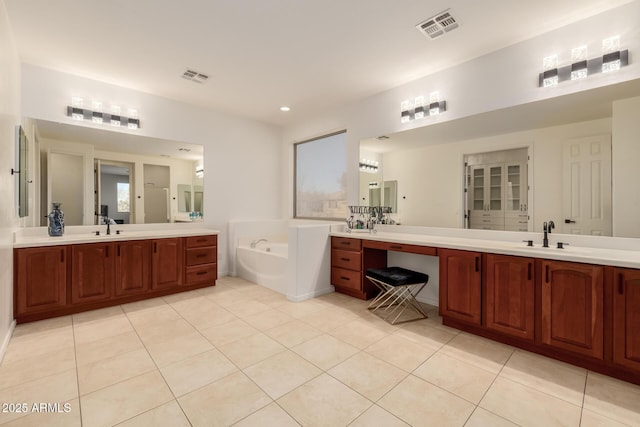 bathroom featuring vanity, tile patterned floors, and a bathing tub