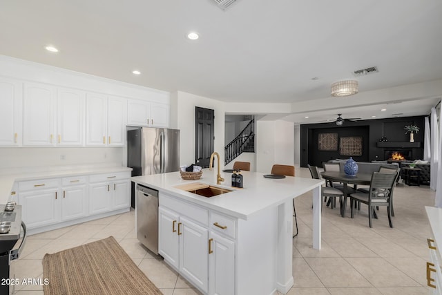 kitchen featuring a center island with sink, appliances with stainless steel finishes, ceiling fan, white cabinets, and sink